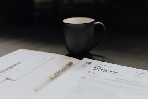 Tax documents, accounting services, and a coffee cup on a table with of a CPA in Houston