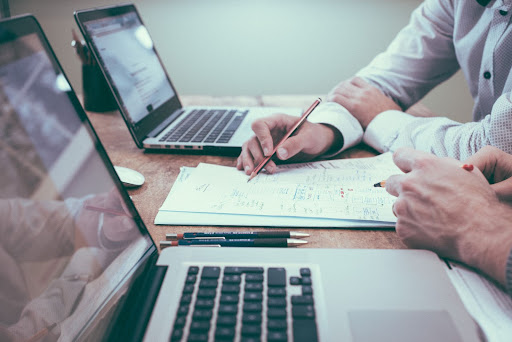 Two CPA in Houston sitting at a table and having a conversation, with tax and accounting services.