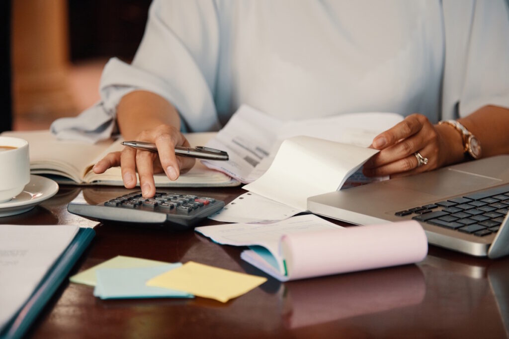 Hands of female entrepreneur working with bills and documents - Evans Sternau CPA Accounting for Startups