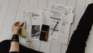 A person organizing and planning their taxes with a calculator.